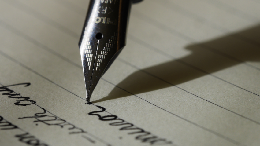 close up of fountain pen writing on paper
